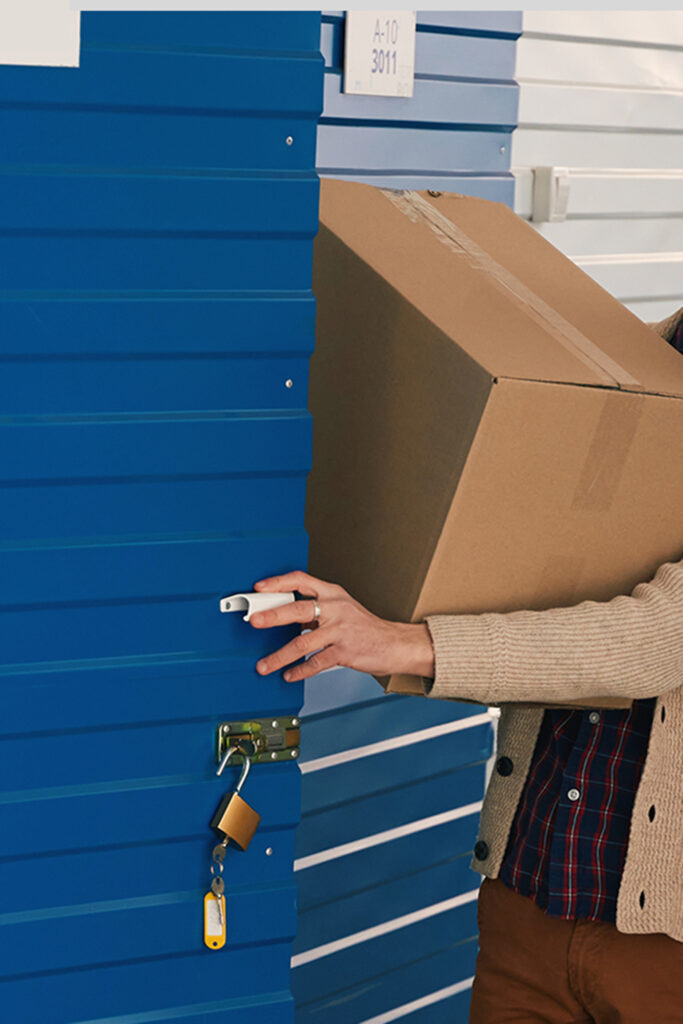 Young woman and man with big cardboard boxes into warehouse