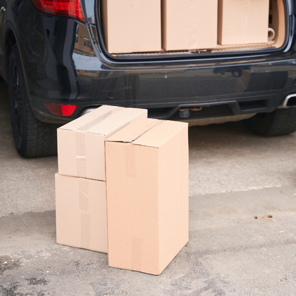 Car trunk packed with cardboard boxes.